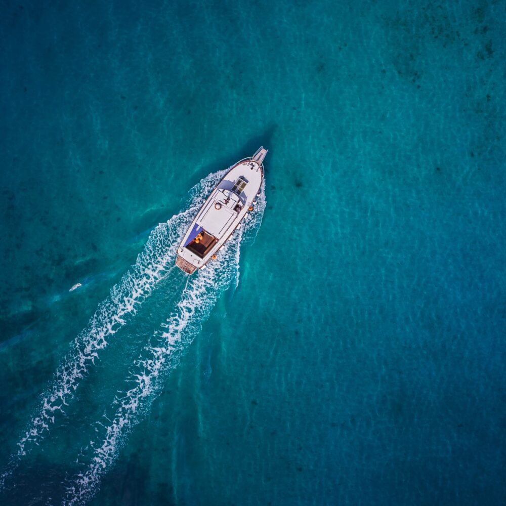 Vintage wooden boat in coral sea. Boat drone photo.